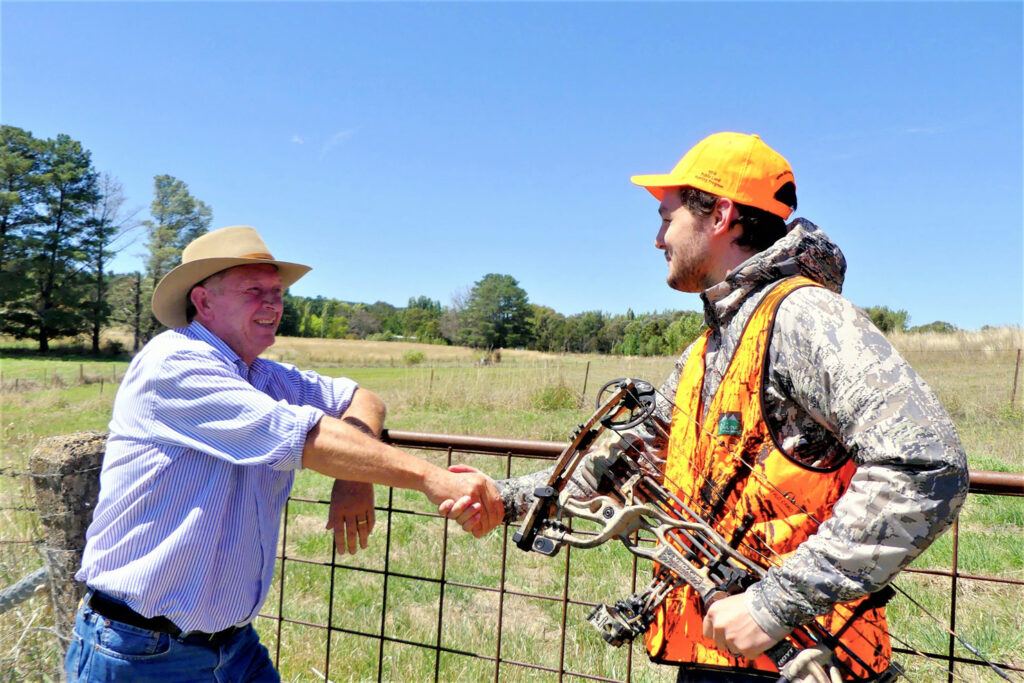 Accessing private property for DIY hunting adventures. Hunter shaking hands with a landowner after securing permission to hunt on his property.