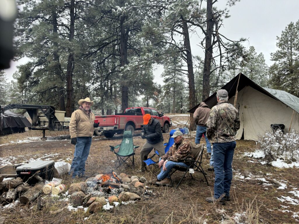 Campsite setup and campers gathered around the campfire