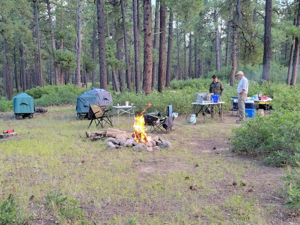 leave no trace campsite campers and their Kamprite tentcots set up around the campfire.