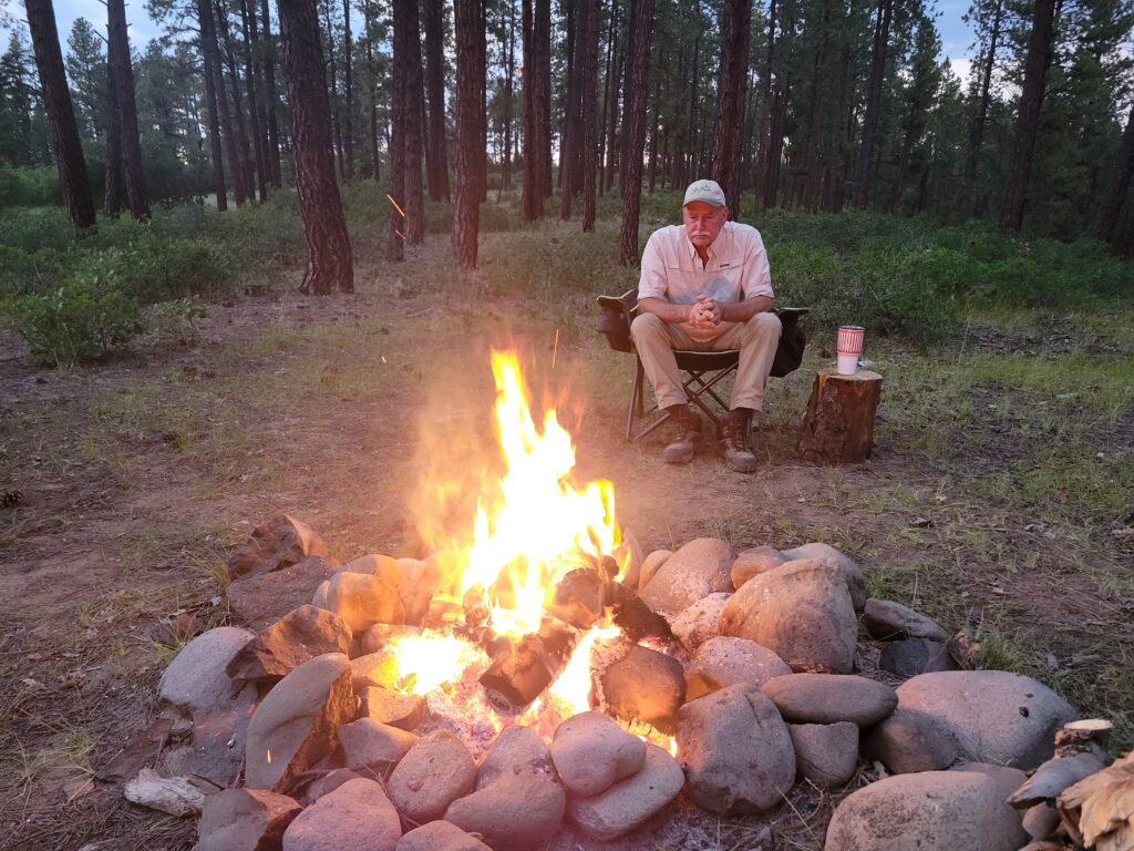 Leave no trace camping principles - Camper watching the campfire