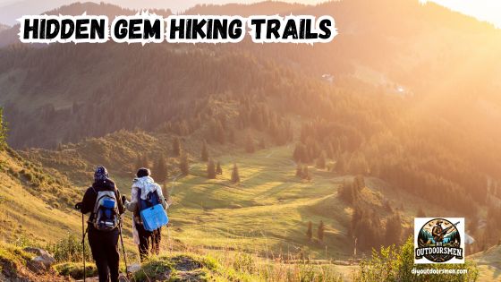 Hidden Gem Hiking Trails in the US featured image showing hikers on a trail in the mountains overlooking a meadow in a valley at sunrise.